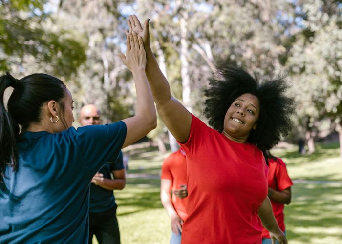 A group of people enjoying a light outdoor activity together in a park.